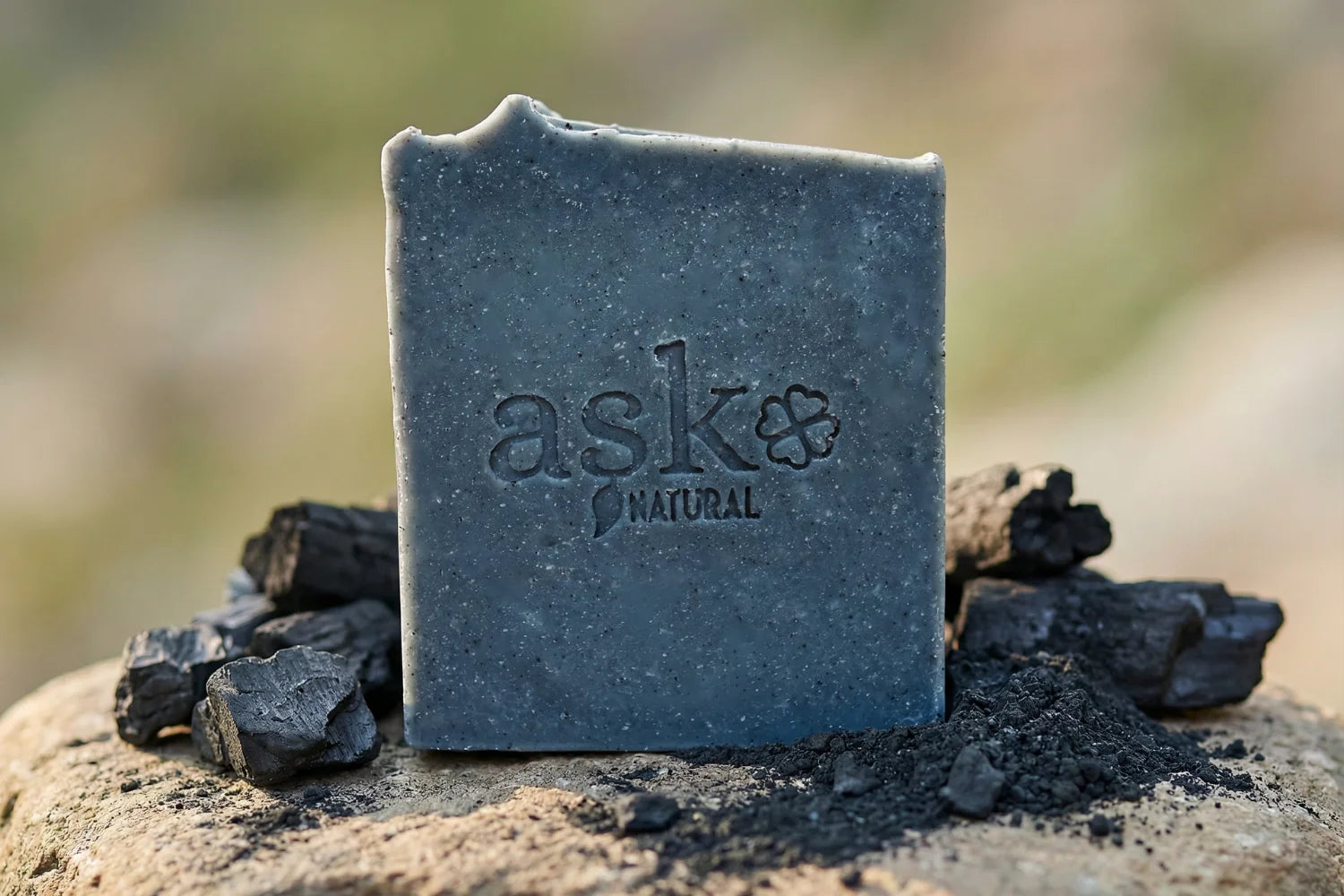 Handgemachte Aktivkohle Naturseife von ASK Natural mit natürlichen Inhaltsstoffen auf Stein, in natürlicher Umgebung.
