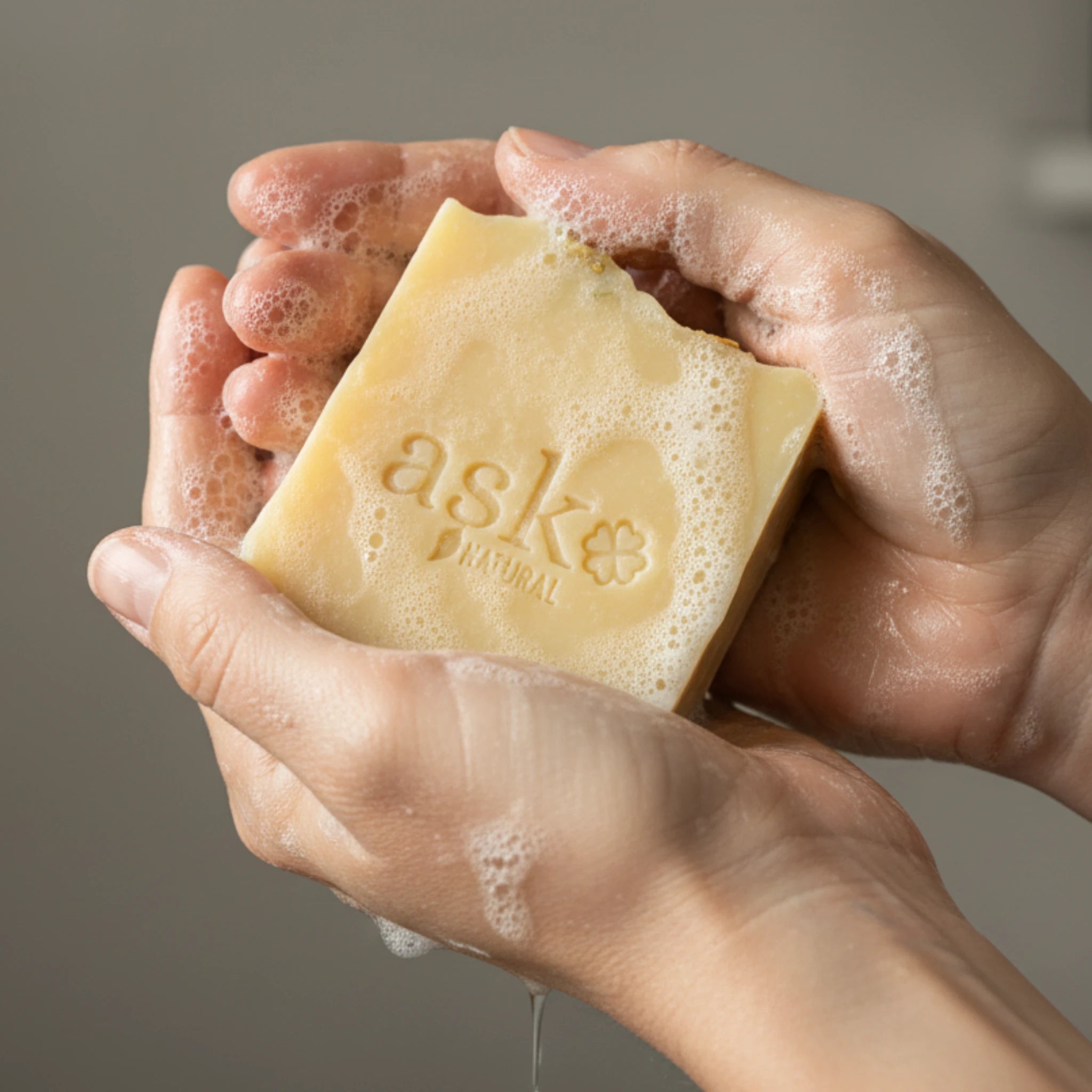 Nahaufnahme einer handgemachten Eselsmilch Seife von ASK Natural mit natürlicher Textur und cremigem Schaum in den Händen, hergestellt im traditionellen Kaltverfahren.