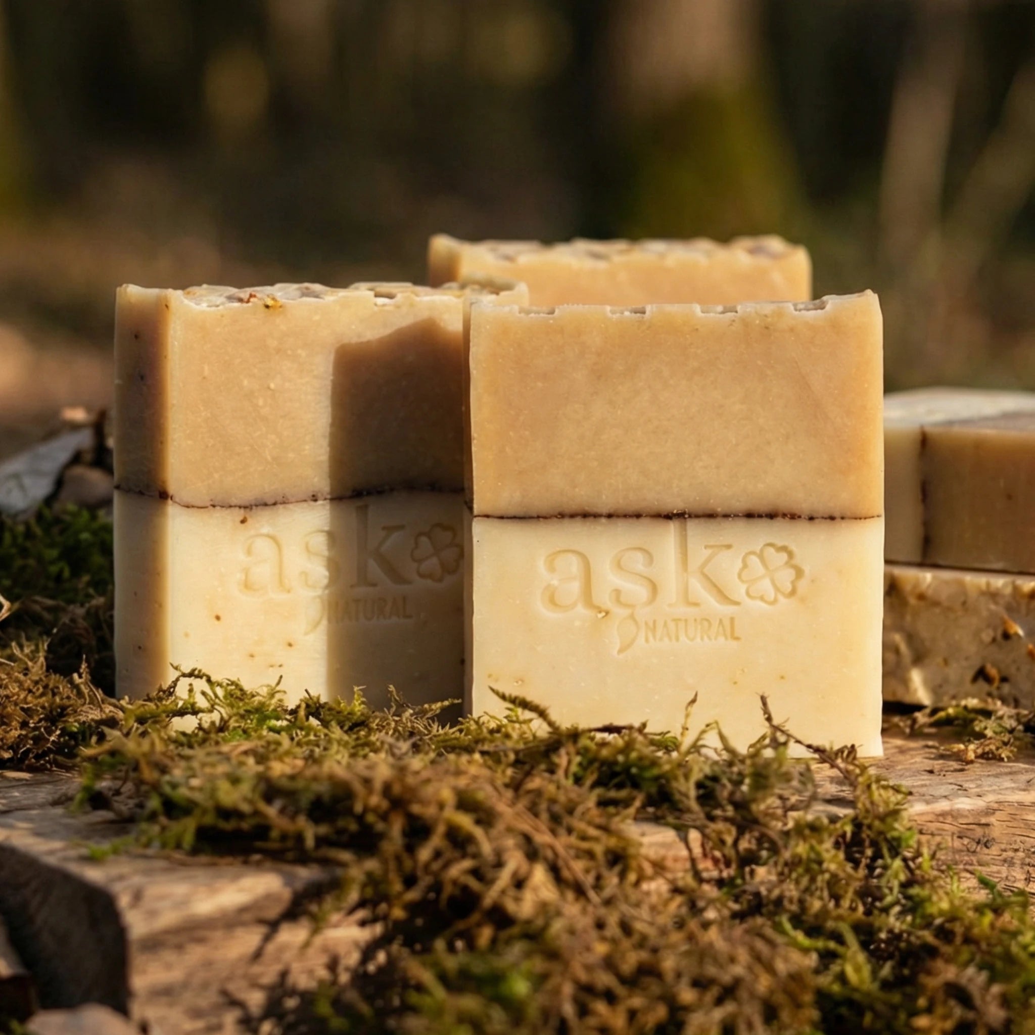 Mehrere handgemachte Hafer Honig Seifen von ASK Natural als Set auf natürlichem Holz und Moos platziert, ideal für Kombination und Mengenrabatt.