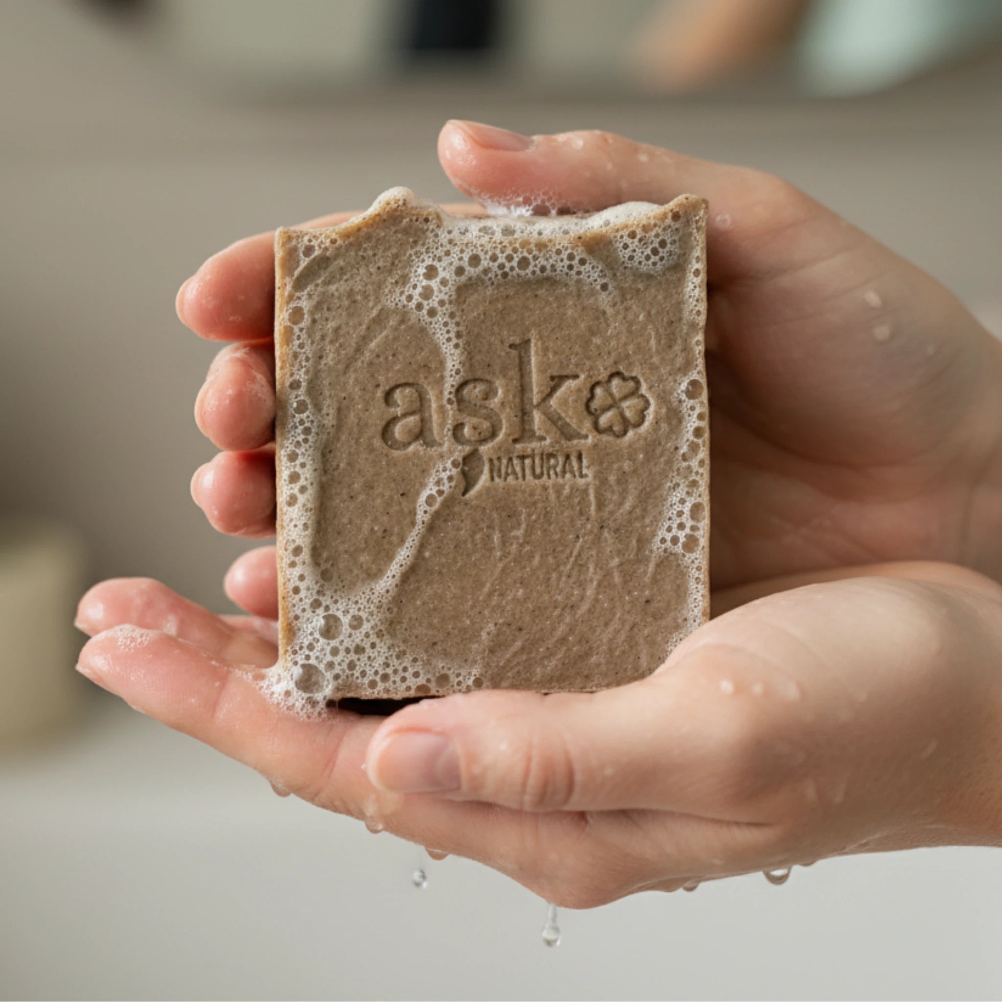 Nahaufnahme einer handgemachten Schwarzkümmelöl Seife von ASK Natural mit natürlicher Textur und cremigem Schaum in den Händen, hergestellt im traditionellen Kaltverfahren.