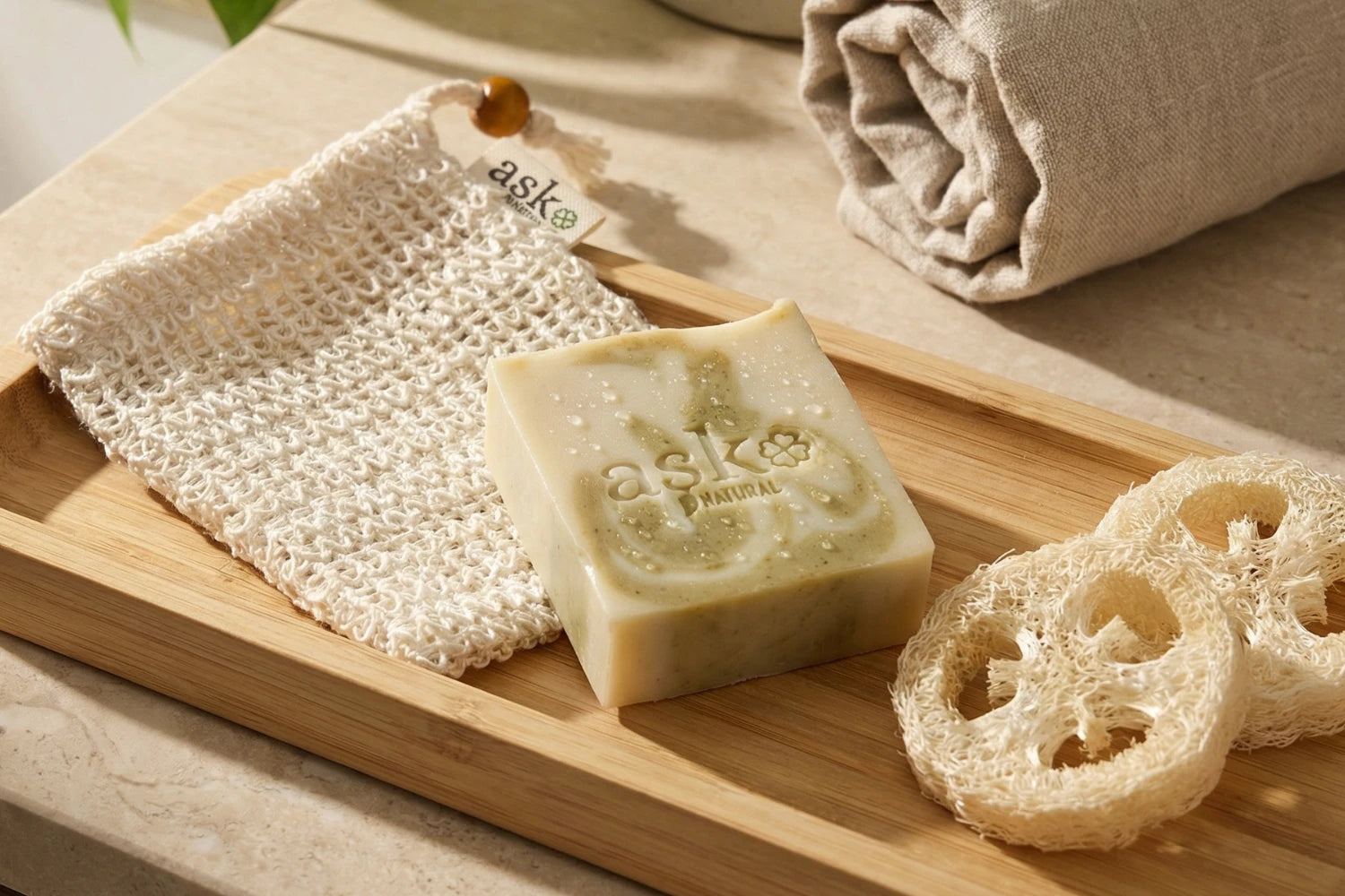 Natürliches Seifensäckchen, neben einer Naturseife von ASK Natural platziert - mit Luffa-Scheiben.