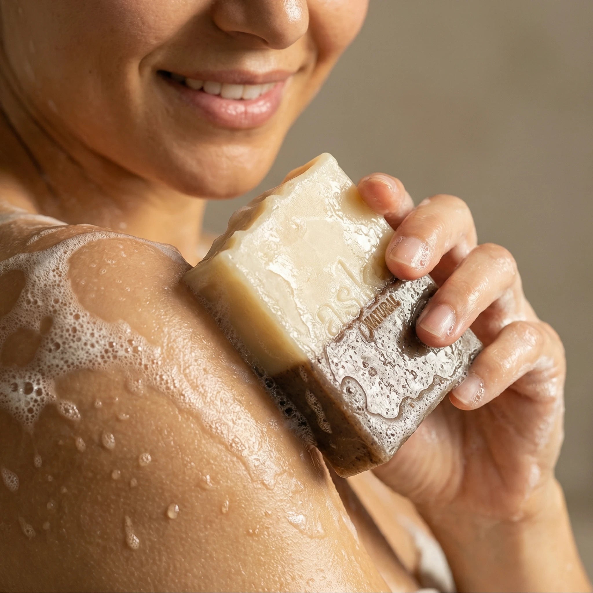 Frau hält handgemachte Zimt Orange Seife von ASK Natural mit cremigem Schaum in den Händen während der Anwendung.